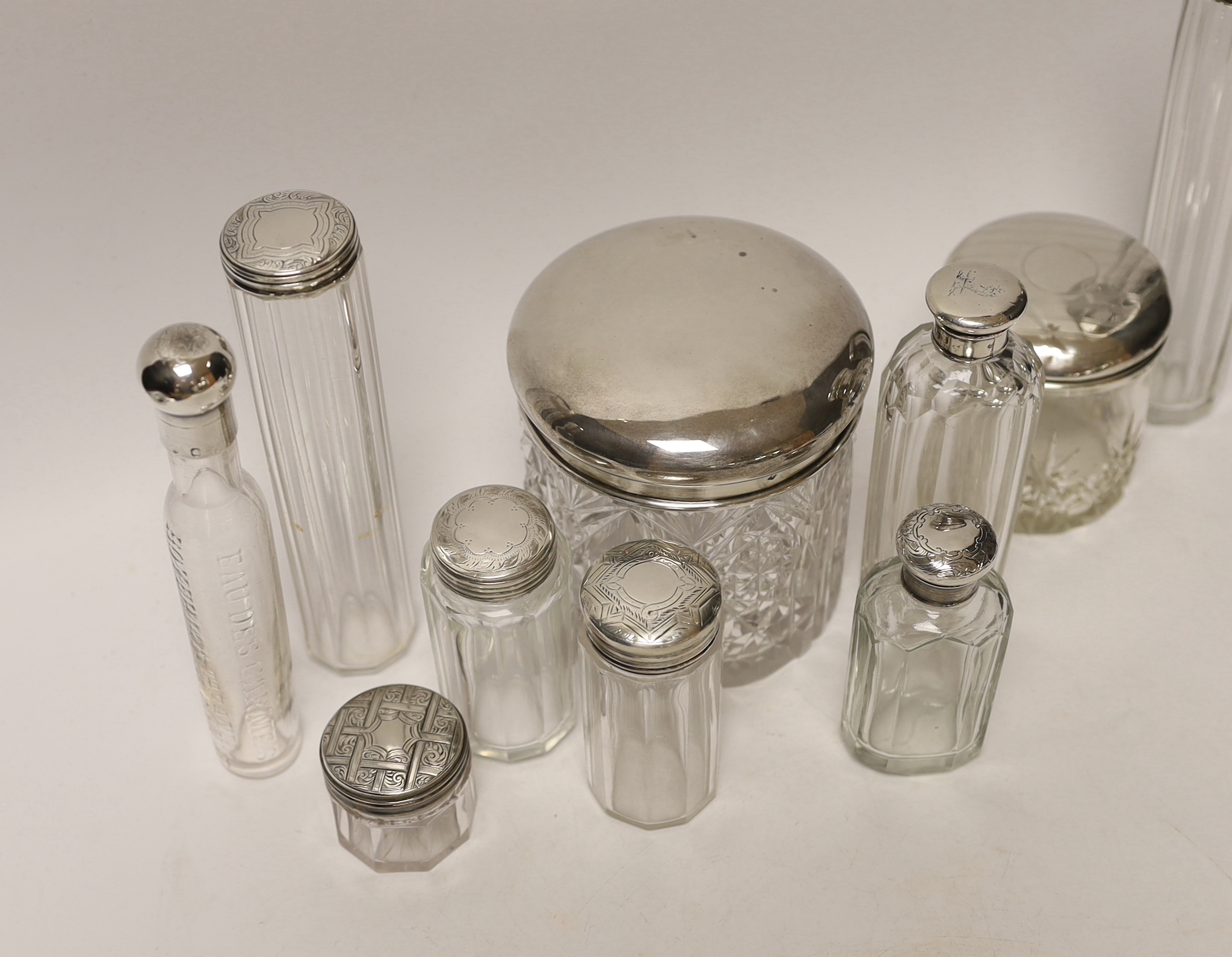 A group of assorted silver or white metal topped toilet jars, tallest 17.6cm.